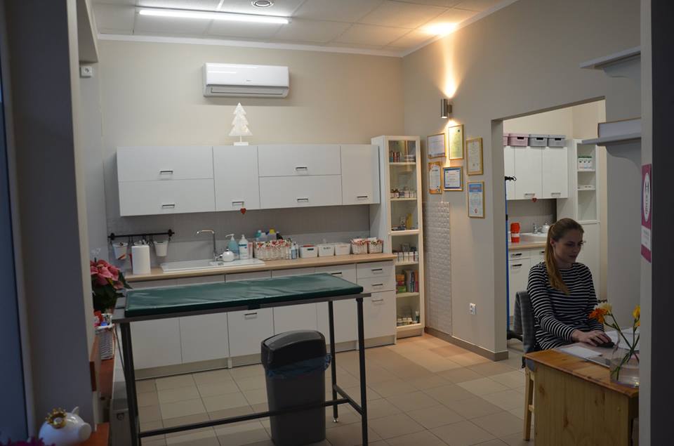 Gabinet zabiegowy przychodni ze stołem, szafkami i stanowiskiem recepcji